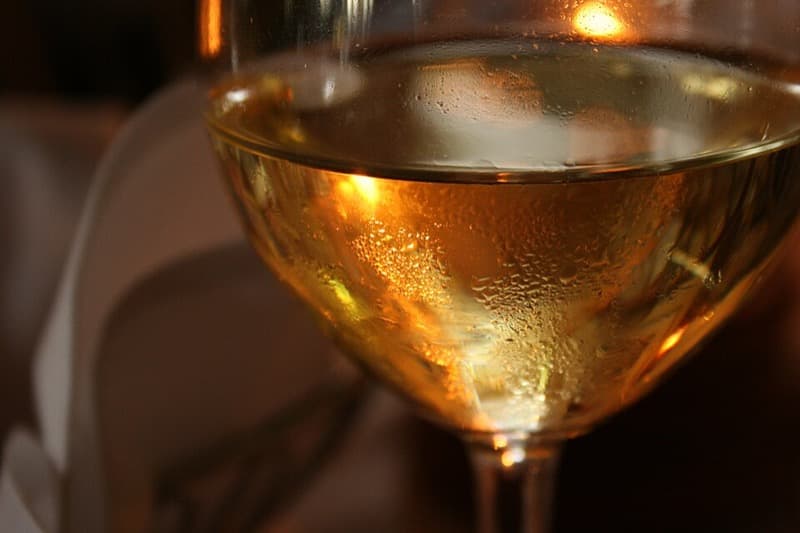 A single glass of water paired with an empty wine glass