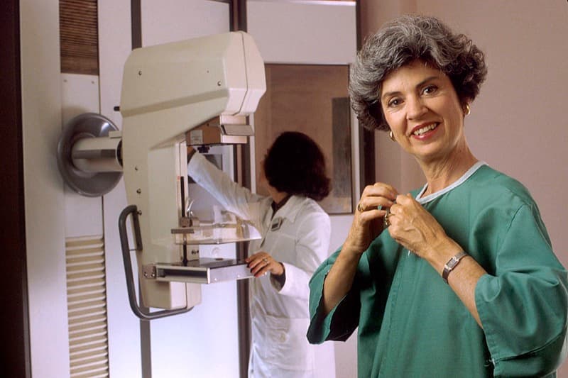 Mammogram screening technician guiding a patient